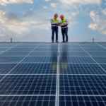 Two engineers stood on a roof looking at the solar panels on the roof